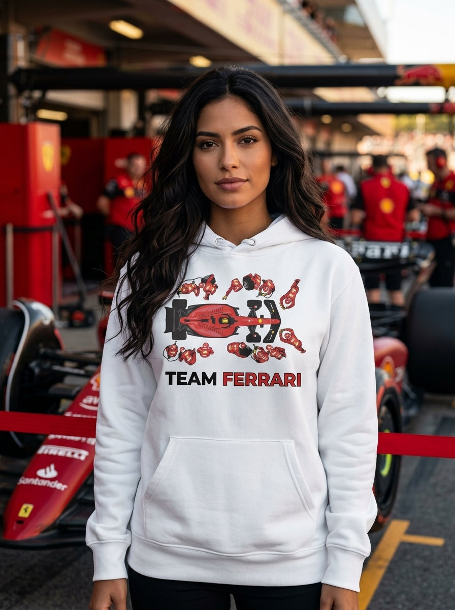Modelo mujer con hoodie Team Ferrari en paddock rojo · Colección Ferrari Drive Gear